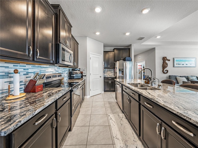 kitchen featuring backsplash, stainless steel appliances, light stone counters, sink, and light tile patterned flooring