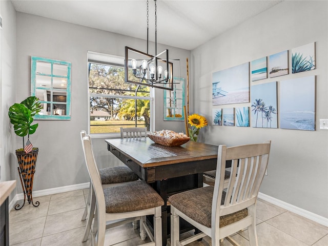 tiled dining space featuring a healthy amount of sunlight and a notable chandelier