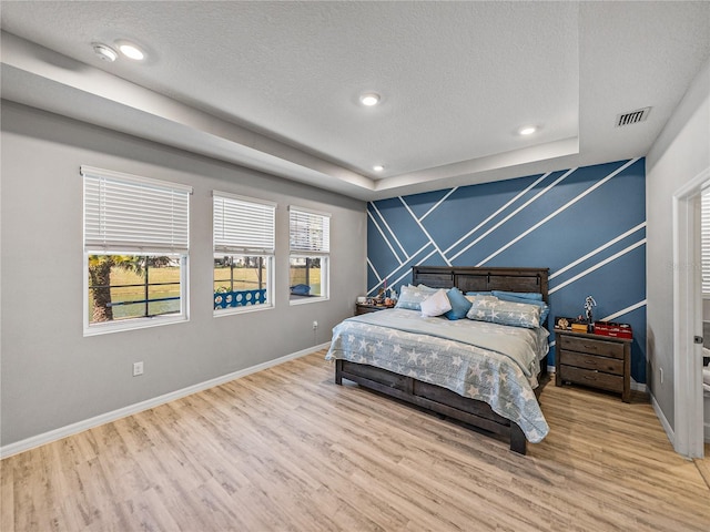 bedroom with a textured ceiling and hardwood / wood-style floors