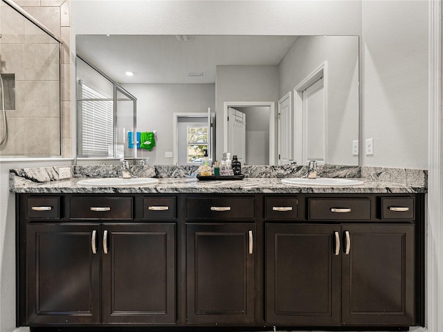 bathroom with tiled shower and vanity