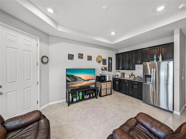 tiled living room featuring a raised ceiling