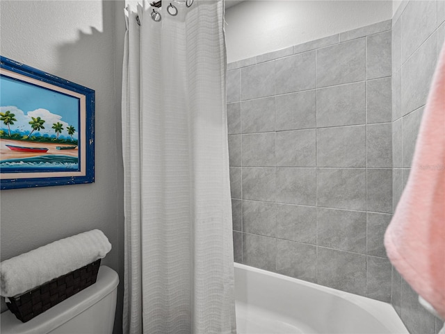 bathroom featuring toilet and shower / bath combo with shower curtain