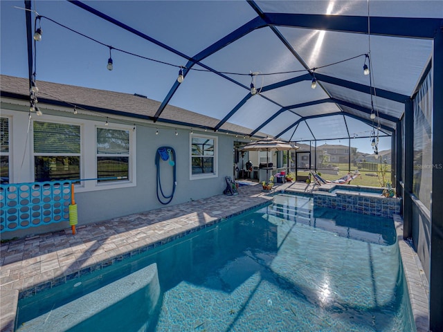 view of swimming pool featuring a patio area, an in ground hot tub, and glass enclosure