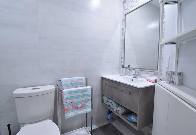 bathroom with vanity, tile walls, and toilet