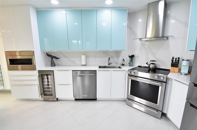 kitchen with sink, stainless steel appliances, ventilation hood, white cabinets, and beverage cooler