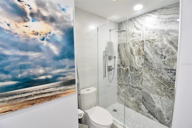 bathroom with a tile shower and toilet