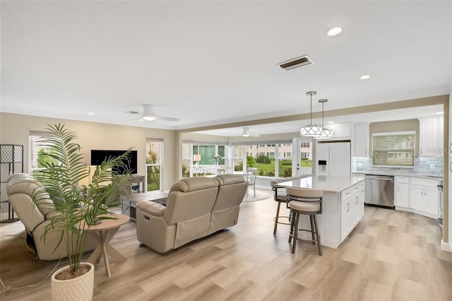 living room with light hardwood / wood-style flooring and ceiling fan