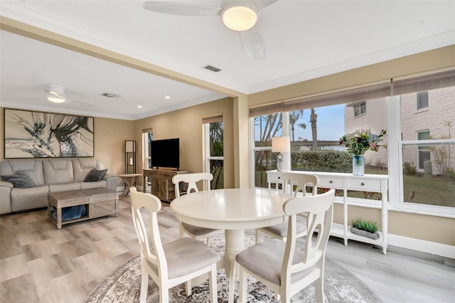 dining space with ceiling fan, crown molding, and light hardwood / wood-style floors