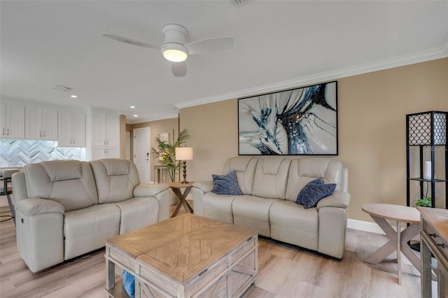 living room with crown molding, ceiling fan, and light wood-type flooring