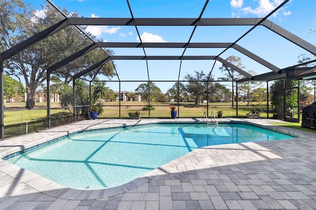 view of pool with a lawn, a patio, and glass enclosure