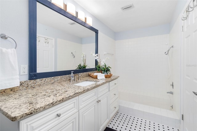 bathroom with vanity and tiled shower