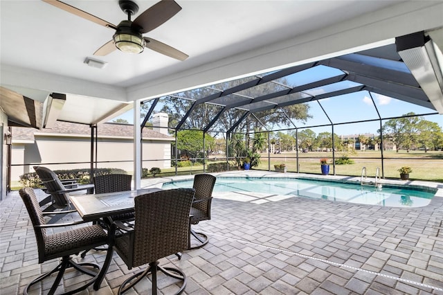 view of swimming pool with a patio, ceiling fan, and glass enclosure