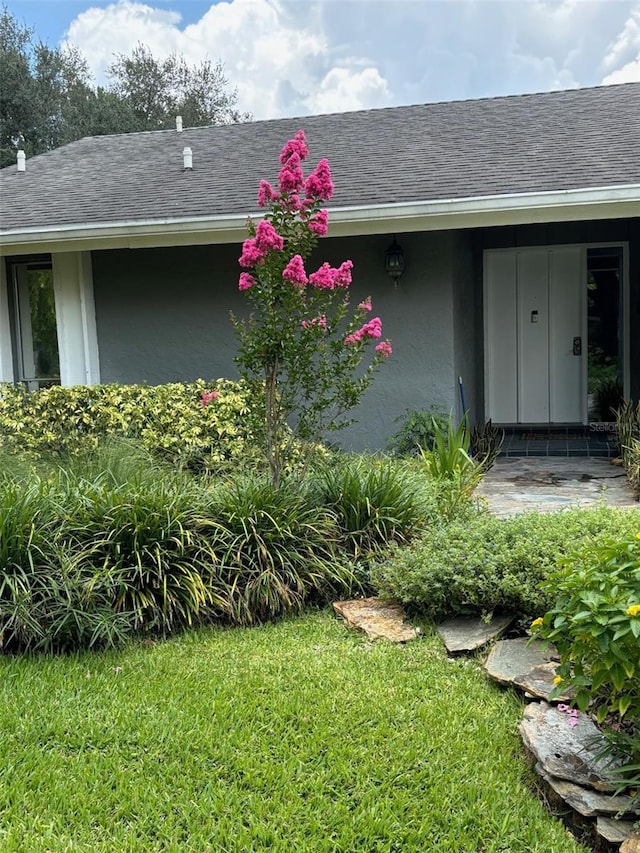 property entrance featuring a lawn