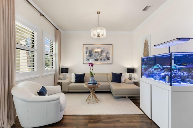 living area with dark wood finished floors, crown molding, visible vents, and an inviting chandelier