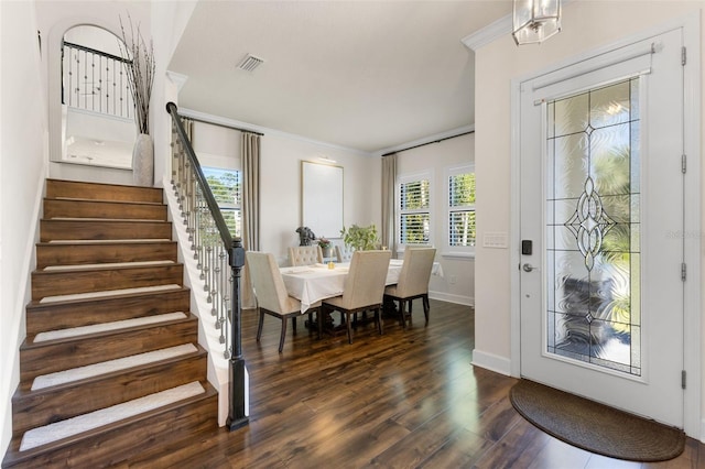 dining room with stairs, dark wood finished floors, visible vents, and a healthy amount of sunlight