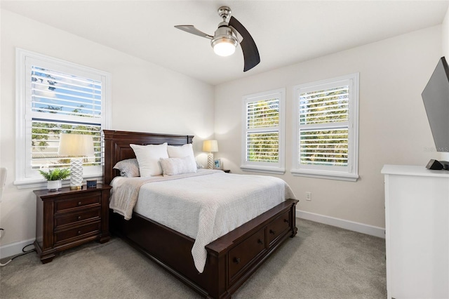 bedroom featuring light colored carpet, baseboards, and ceiling fan