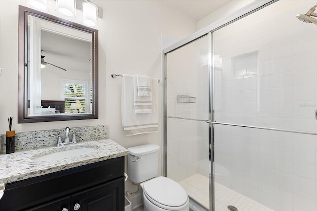 full bathroom featuring a shower stall, toilet, vanity, and ceiling fan