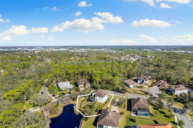 drone / aerial view with a residential view, a wooded view, and a water view