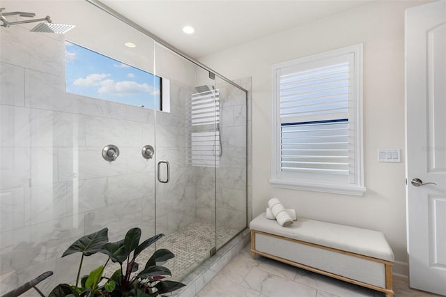 bathroom with marble finish floor and a stall shower