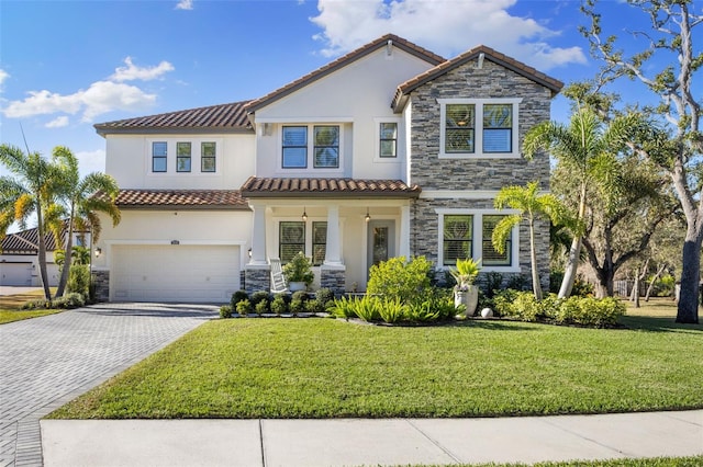 mediterranean / spanish-style house with stucco siding, a front lawn, decorative driveway, stone siding, and a garage