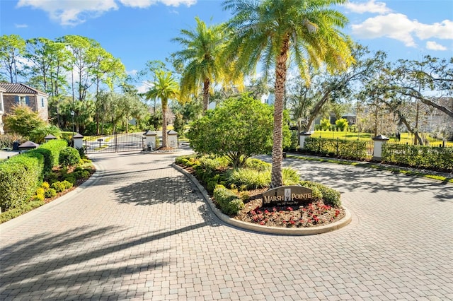 view of home's community featuring decorative driveway and a gate