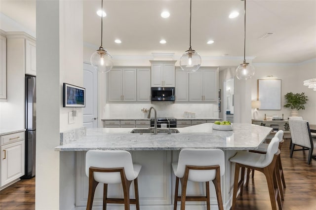 kitchen featuring backsplash, a kitchen bar, appliances with stainless steel finishes, dark wood-style floors, and a sink