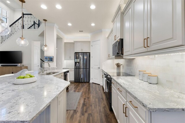 kitchen featuring tasteful backsplash, dark wood-type flooring, ornamental molding, black appliances, and a sink