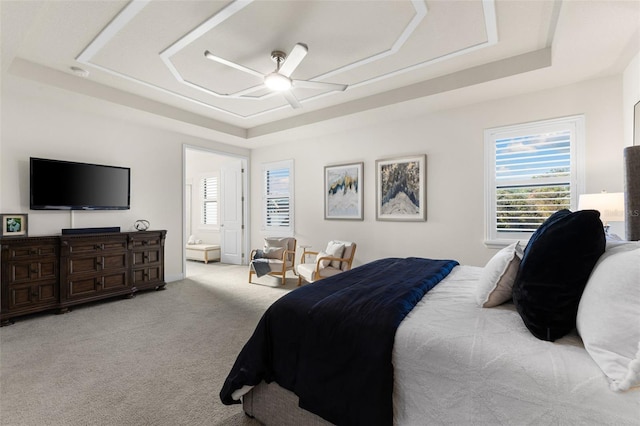 bedroom with a tray ceiling, carpet floors, and ceiling fan