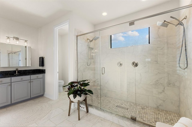 bathroom with vanity, toilet, a stall shower, and marble finish floor