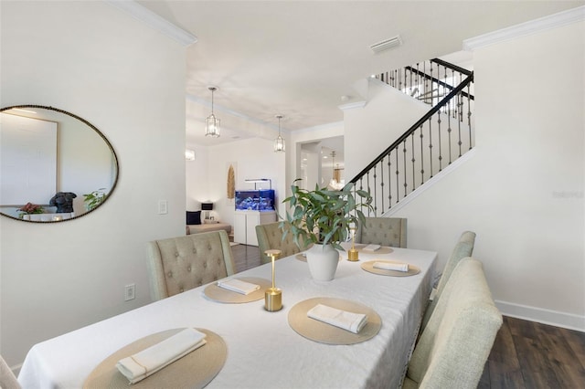 dining room with wood finished floors, baseboards, visible vents, stairs, and crown molding