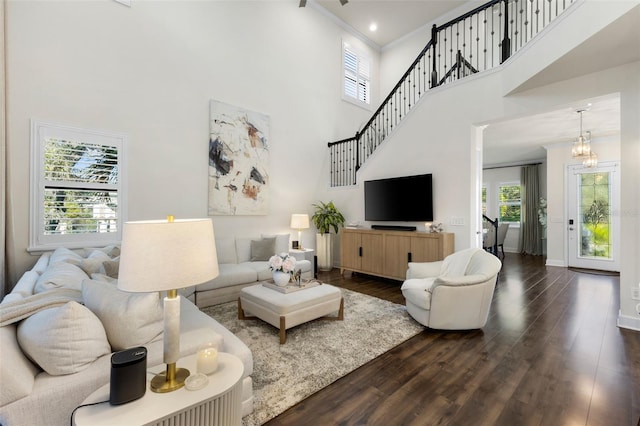 living area featuring crown molding, plenty of natural light, baseboards, and dark wood-style flooring