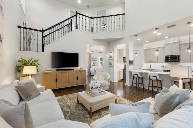 living room featuring visible vents, dark wood-type flooring, and baseboards