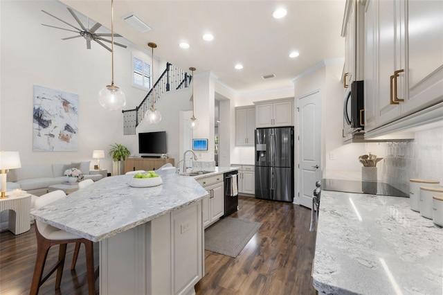 kitchen with dark wood-type flooring, black appliances, a sink, backsplash, and open floor plan