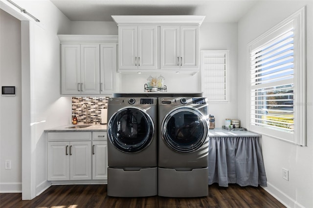 washroom with a sink, plenty of natural light, dark wood-style flooring, and washer and clothes dryer