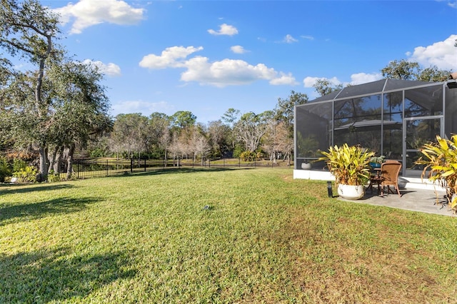 view of yard featuring a patio area, glass enclosure, and fence