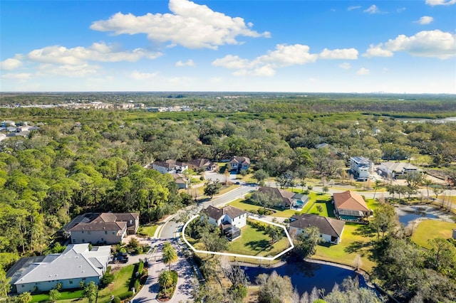 drone / aerial view featuring a water view, a forest view, and a residential view