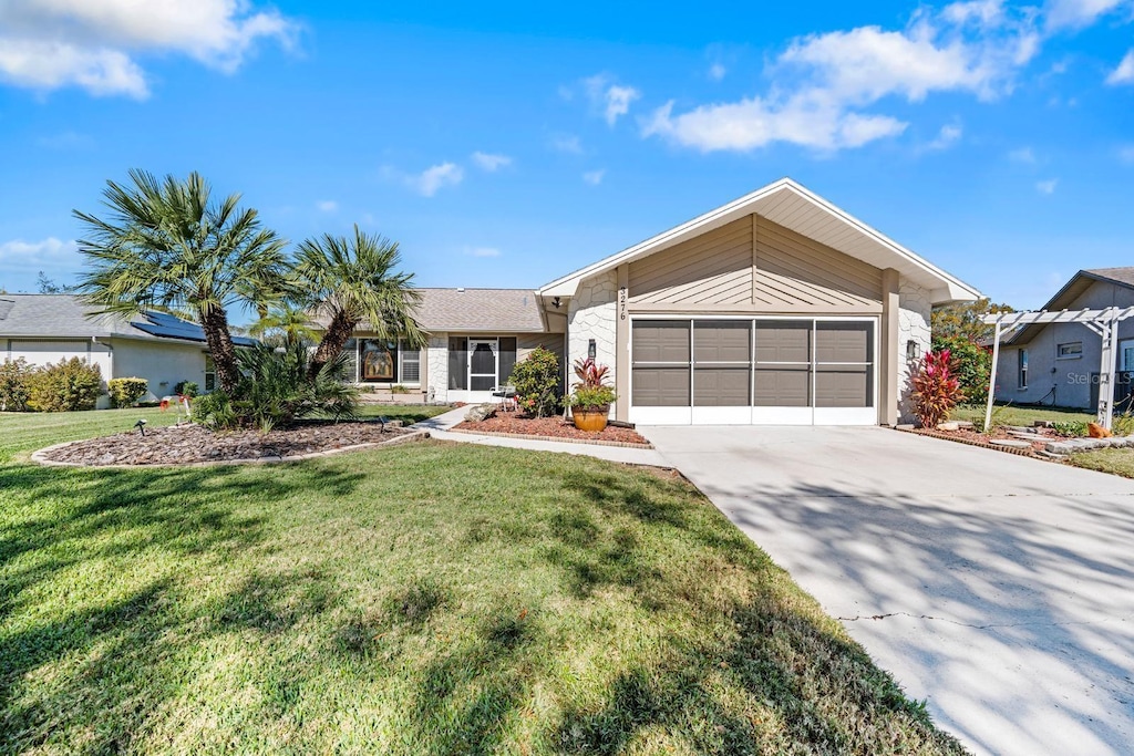 ranch-style home featuring a garage and a front lawn