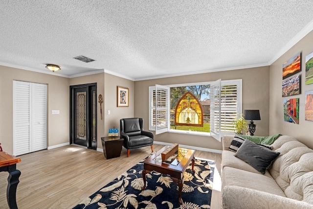 living room with a textured ceiling, light wood-type flooring, and crown molding