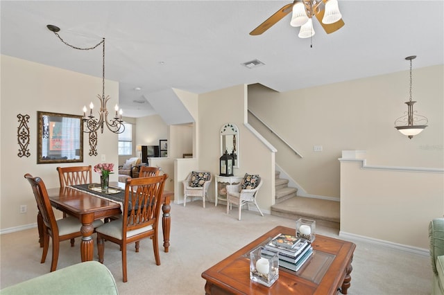 carpeted dining room featuring ceiling fan with notable chandelier