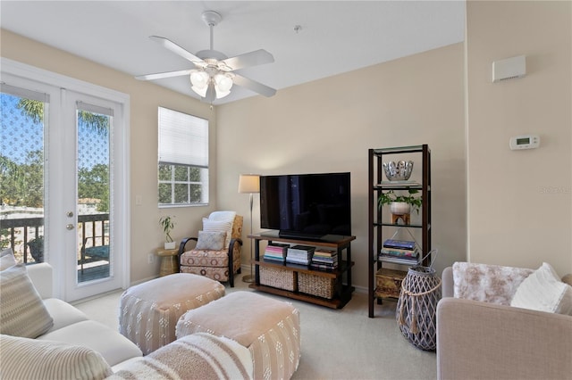 living room with french doors, ceiling fan, and light colored carpet