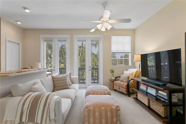 sitting room with ceiling fan, light colored carpet, and french doors