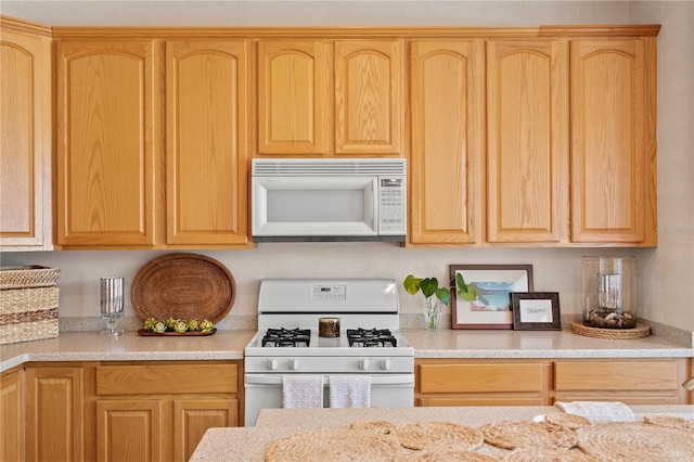 kitchen featuring white appliances and light stone countertops