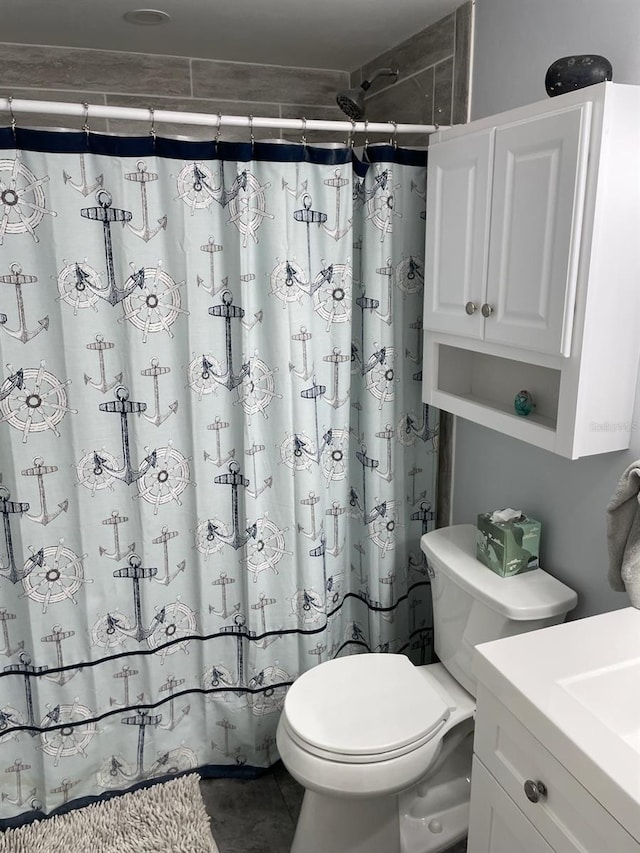 bathroom with tile patterned flooring, vanity, walk in shower, and toilet