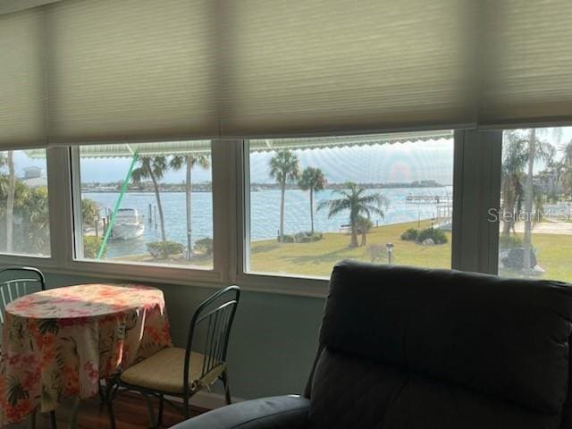 sunroom featuring a water view