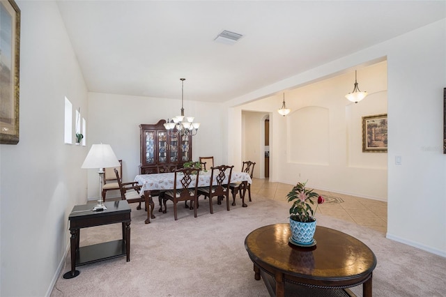 dining space featuring light carpet and a notable chandelier