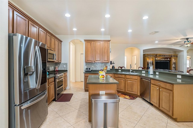 kitchen with a kitchen island, appliances with stainless steel finishes, sink, backsplash, and kitchen peninsula