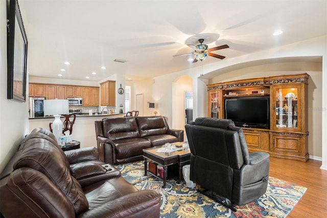 living room with ceiling fan and light hardwood / wood-style floors