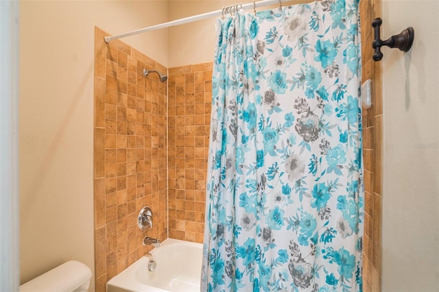 bathroom featuring shower / bath combination with curtain and toilet