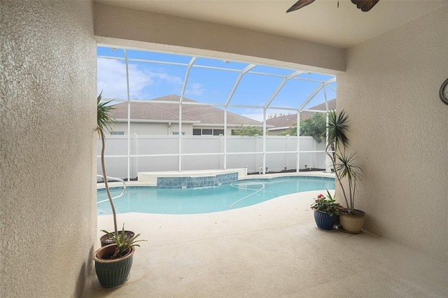 view of swimming pool featuring ceiling fan, a patio, and glass enclosure