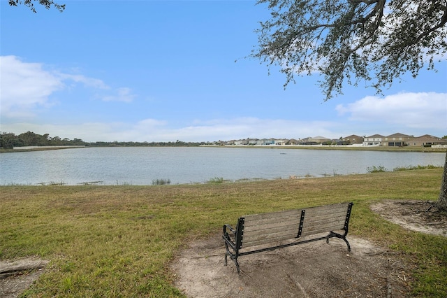 view of home's community with a water view and a lawn